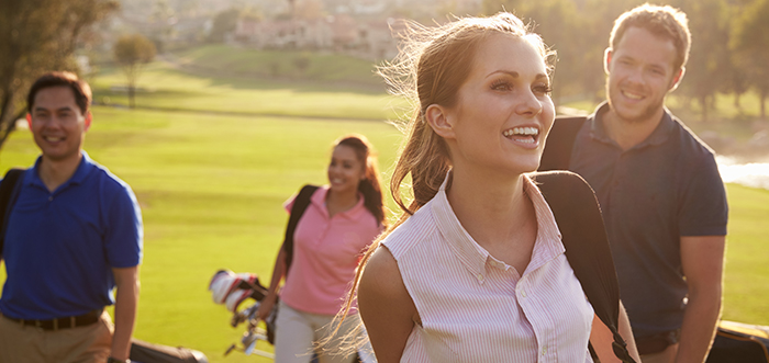 A group of golfers walking on a golf course