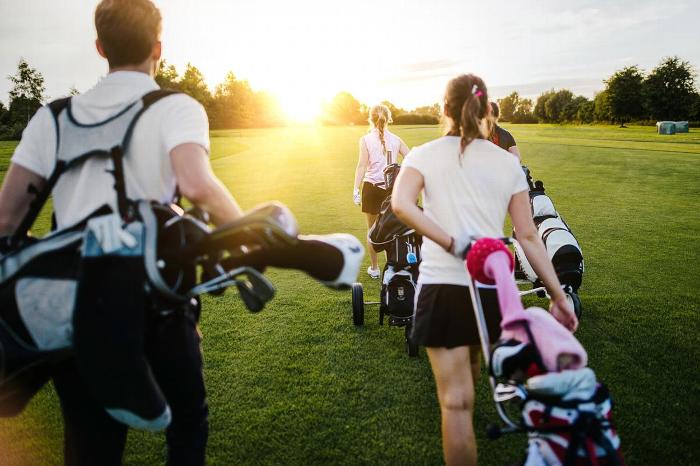 A group of golfers walking on a golf course